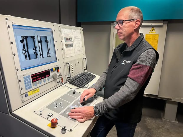 Quality assurance employee operating control panel for machinery inspection in a factory