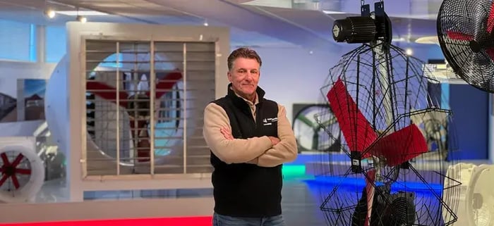 Mitarbeiterin posiert für Ventilatorenteile in einem Ausstellungsraum.
