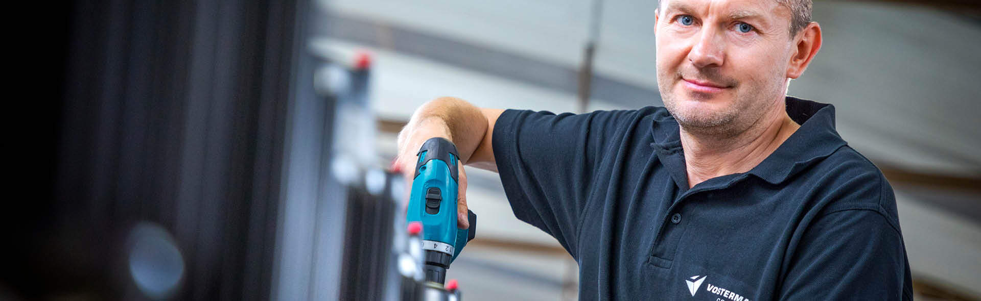 Werknemer gebruikt elektrische schroevendraaier bij motorassemblage