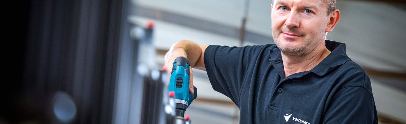 Mitarbeiter verwendet elektrischen Schraubenzieher im Motorenmontageprozess