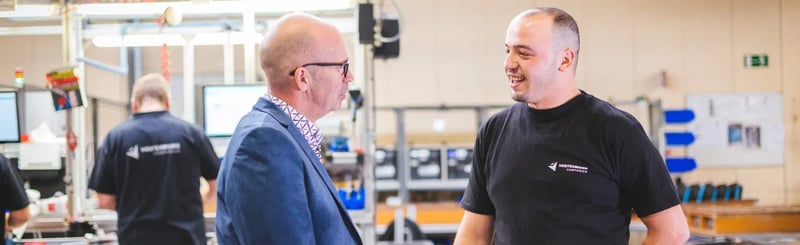Twee werknemers praten in een productiegebied van de fabriek