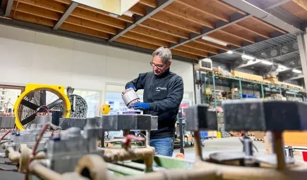 Empleado trabajando con componente de motor en un taller de fábrica