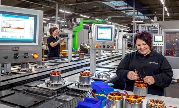 Deux femmes travaillent dans une usine en enroulant des bobines sur des machines pour des équipements de ventilation
