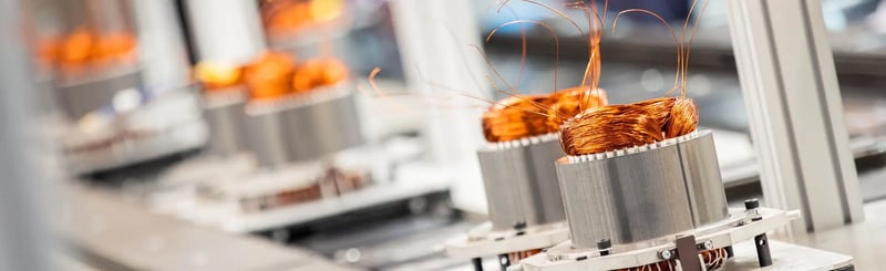Gros plan sur des bobines de cuivre enroulées pour des équipements de ventilation dans une usine