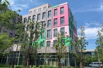 Edificio moderno colorido con árboles y cielo azul alrededor