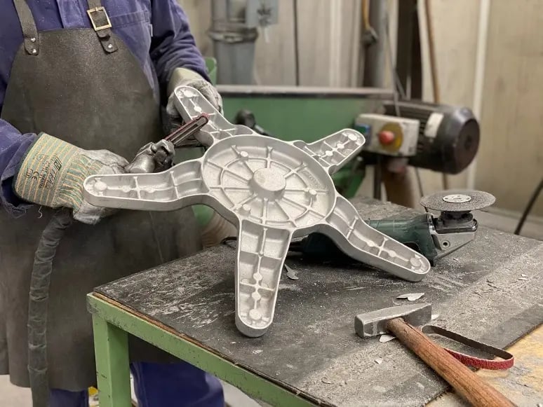 Arbeiter formt ein großes Aluminiumteil für industrielle oder medizinische Zwecke auf einer Werkbank